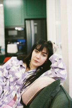 A young woman is sitting on the couch.