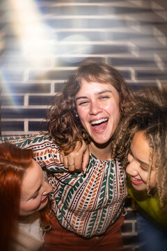 Friends laughing with joyful expressions in warm setting