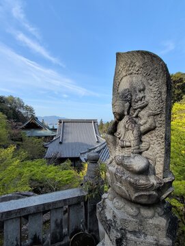 Miyajima Island Stone Guardian Statue with Temple Roof and Sea View