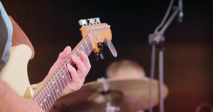Concert stage with live rock guitar music &ndash; band perform set at entertainment festival event. Close up on instrument of electric guitarist.