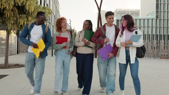 Diverse group of university students walking and talking on campus