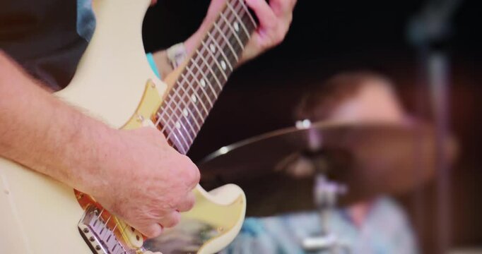 Concert stage with live rock guitar music &ndash; band perform set at entertainment festival event. Close up on instrument of electric guitarist.