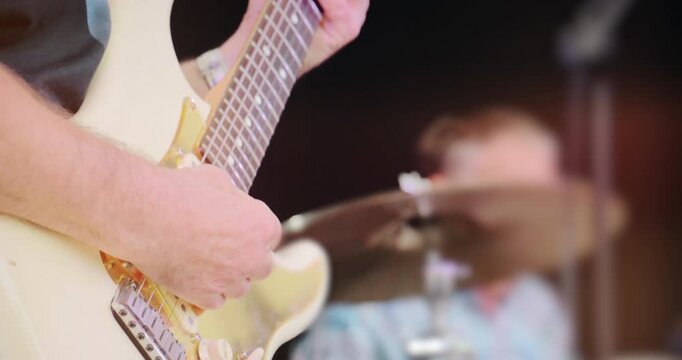 Concert stage with live rock guitar music &ndash; band perform set at entertainment festival event. Close up on instrument of electric guitarist.