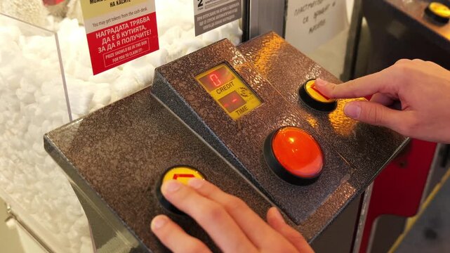 Person pressing buttons on arcade game control panel
