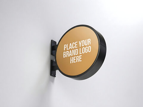 Round gold street signboard mockup on black metal bracket mounted on white wall, blank circular store sign template with placeholder text