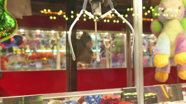 Arcade claw machine game attempting to grab stuffed animal toy