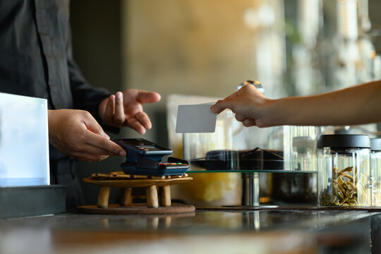 Customer Paying with Credit Card at Cafe or Restaurant Counter Using Card Payment Terminal