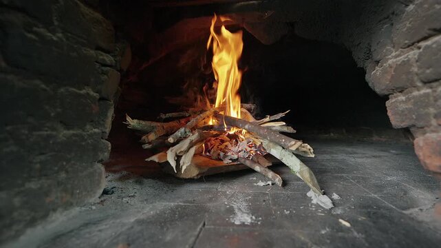 close up of wood burning fire inside traditional brick oven