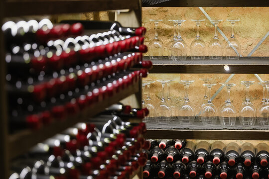 Rows of red‑sealed wine bottles rest in a dimly lit cellar, showcasing elegant storage and timeless craftsmanship. Perfect for themes of luxury, tradition, and fine winemaking.
