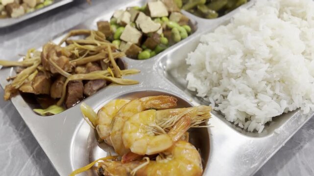 Blurred Closeup of Mixed Asian Meal with Shrimp and Rice in Metal Tray