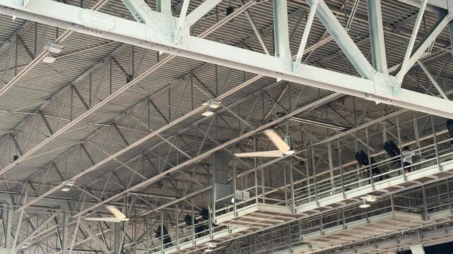 Industrial fans in the ceiling rafters of a large event venue structure background