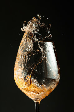 An image of white wine being splashed into a glass.