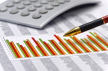 Fototapeta premium Ein Stift liegt auf Tabellen mit vielen Zahlen zur finanziellen Statistik und Berechnung mit einem Chart