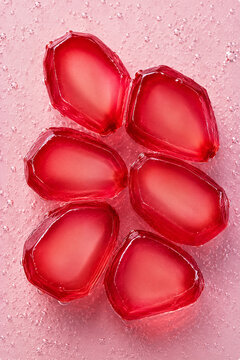 Fresh pomegranate arils surrounded by sparkling bubbles in a vibrant macro composition. Bright healthy food background with refreshing texture.