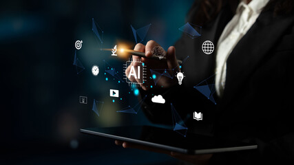Obraz premium Business professional interacting with futuristic artificial intelligence interface while holding tablet in dark atmosphere with glowing icons Haptic.
