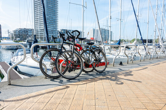 Bike parking on the city street near the sea port on sandy beach summer weather. Summer sport, travel concept.