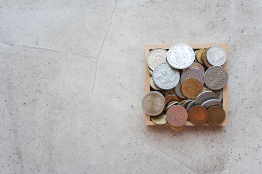 Pile of old gold and silber coins in wood box on the natural background.