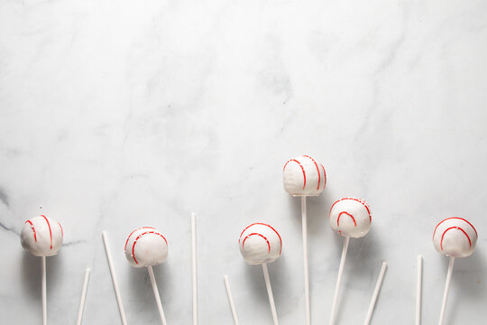 Decorated cake pops with sticks against a light background.