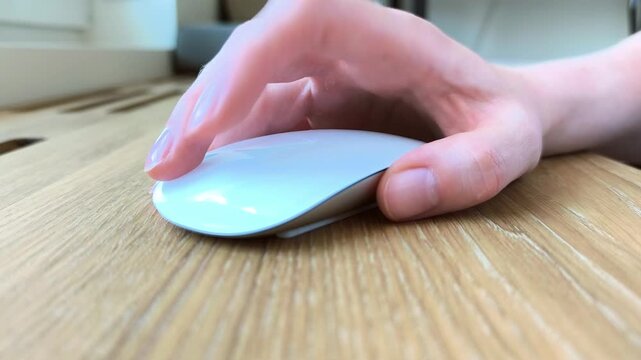 Front view of a hand scrolling with a computer mouse. Fingers rotating the wheel during everyday navigation. Close-up scene of digital browsing at a desk..