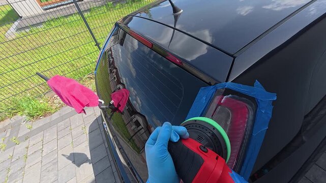 A rear car light is polished by hand during detailing work. The video shows automotive cleaning, plastic restoration, and careful surface treatment.