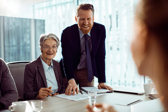 Senior and younger colleagues collaborating in a modern office meeting