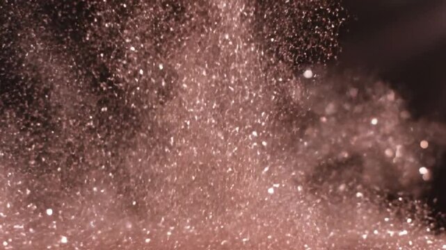 Shimmering rose gold particles exploding and swirling abstract motion background