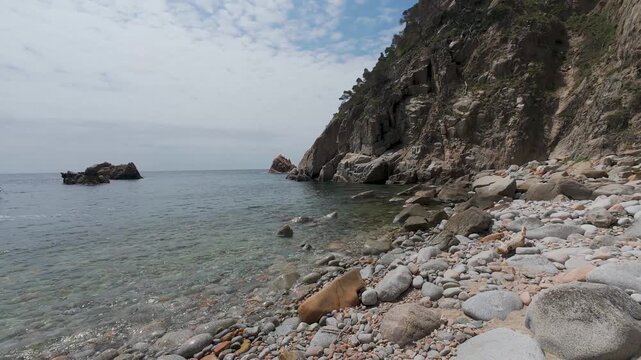 Rocky cliff shoreline with clear sea water