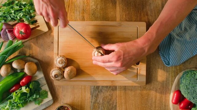 Man cut champignon button Fresh Royal oyster mushrooms, cooking on a wooden cutting board cafe asian restaurant kitchen, vibrant scene of food preparation