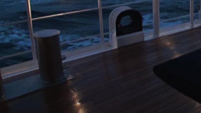 Experience a nocturnal passage across the mighty Arctic Ocean. Deck railings and wet surfaces shimmer with reflected light as dark, powerful waves endlessly surge.