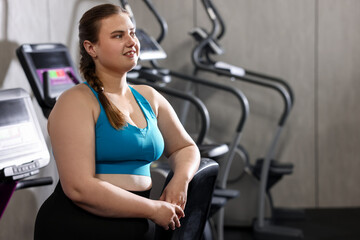 Fototapeta premium Portrait of happy overweight woman in gym, space for text
