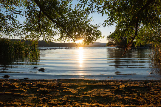 Setting sun reflecting on the calm waves of Klamath Lake at Moore park, Klamath Falls, Oregon.