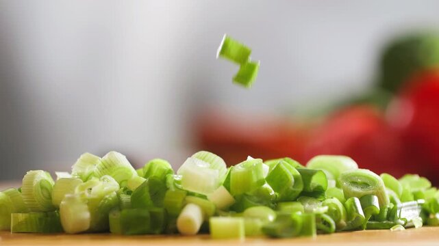 Bunch of green onion feathers with drops of water on a cutting board, Close-up macro rotating shot. 