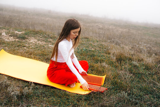 Woman placing sadhu boards on a yoga mat for meditation