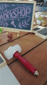 Leathercraft workshop table with alphabet stamping tools, mallet and chalkboard sign, Handmade crafting workspace with leather embossing kit, wooden workbench and DIY equipment, 4k vertical video
