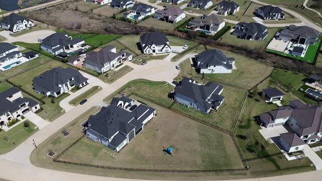 Natural drainage creek flows through Sanctuary subdivision beside upscale homes. High angle perspective depicts swimming pools, patio areas, cul de sac street in Flower Mound, Dallas suburbs, TX