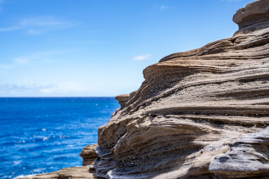 Tuff &mdash; Gray to brown bedded crystal-lithic tuff and lapilli tuff. Spitting Cave, Honoulu, Oahu, Hawaii.  