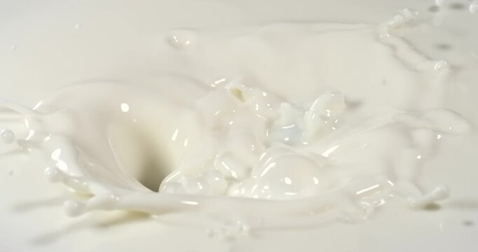 Blueberries falling into milk in slow motion