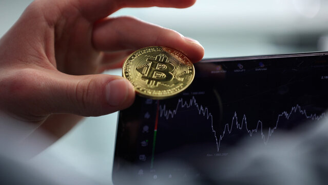 Successful trading transaction on the phone, Bitcoin in hands