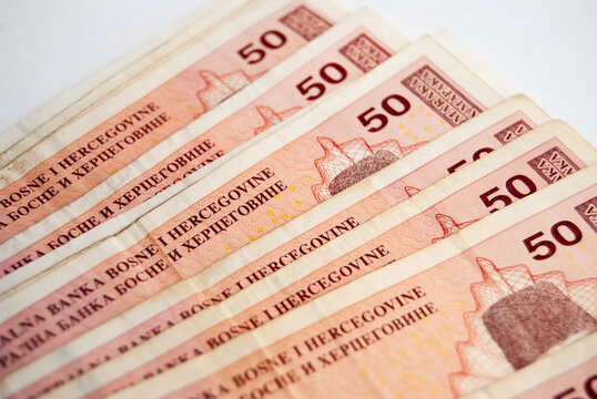Bosnian paper money in close-up, featuring convertible mark banknotes with colorful patterns and traditional imagery.