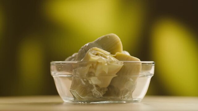 Marinated artichokes in a glass jar isolated on a white background. Mediterranean preserved vegetables, gourmet appetizer, healthy organic food, ready to eat, close-up.