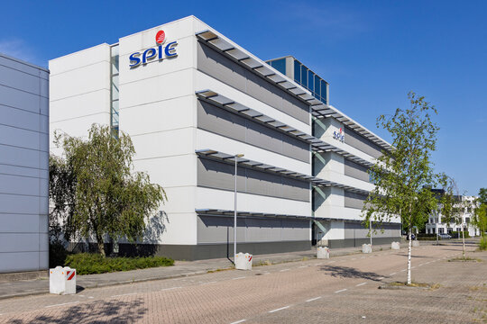Utrecht, Netherlands - 15 July 2026: Wide view of the modern SPIE company office building with parking lot and trees on a sunny summer day.