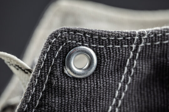 Canvas sneaker macro showing eyelet and detailed stitching