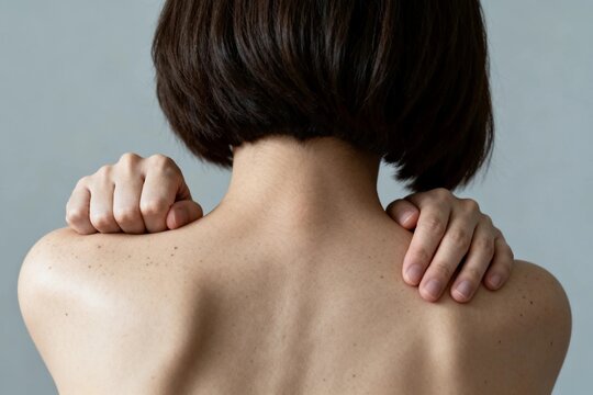 Back view of person receiving shoulder and neck massage
