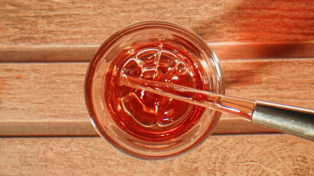 Pouring shot of red bitter, Cognac, whisky, Campari, Aperol, Cherry Vermouth Negroni, spanish wine drink, Alcoholic Americano Cocktail bitter, sweet vermouth and soda water, close up of making drink