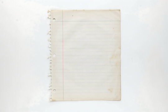 Old blank lined notebook paper torn from spiral notebook isolated on white background
