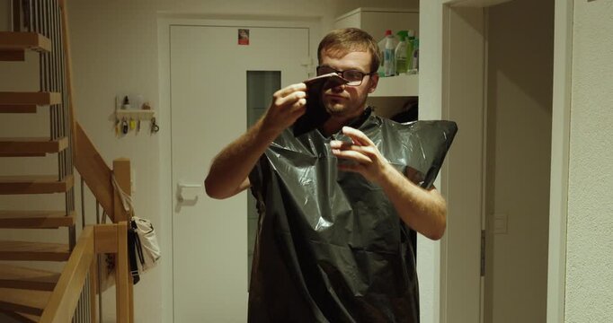 A man wearing a garbage bag as improvised clothing shows an empty wallet, symbolizing poverty, financial hardship, and lack of money.