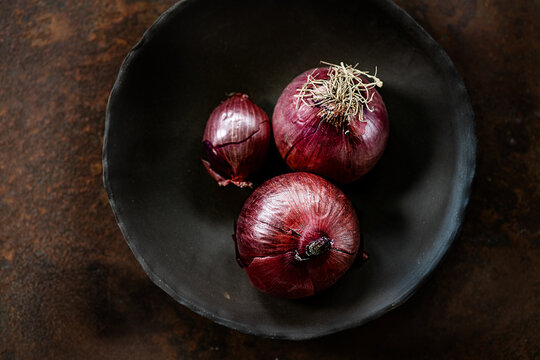 Red onions on a wooden background