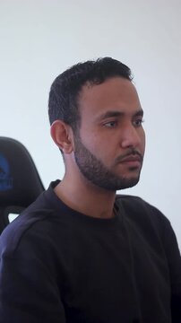 Focused Young Man Sitting at Desk Working on Computer in Home Office