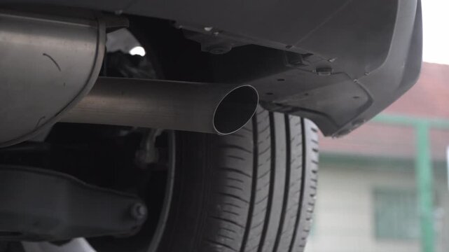 Exhaust pipe of modern car releasing emissions cleaned by catalytic converter. Euro 5 environmental standards, catalytic converter filtration, and automotive air pollution