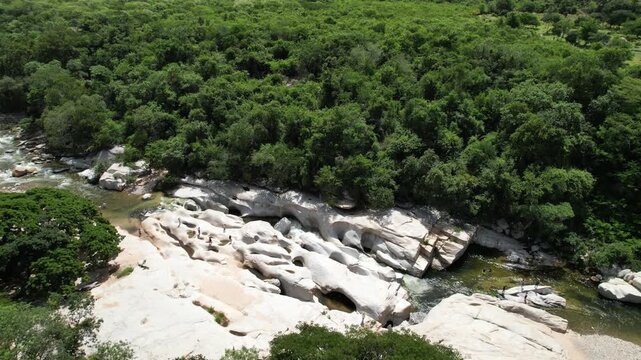 Aerial view of river flowing through rocky valley forest